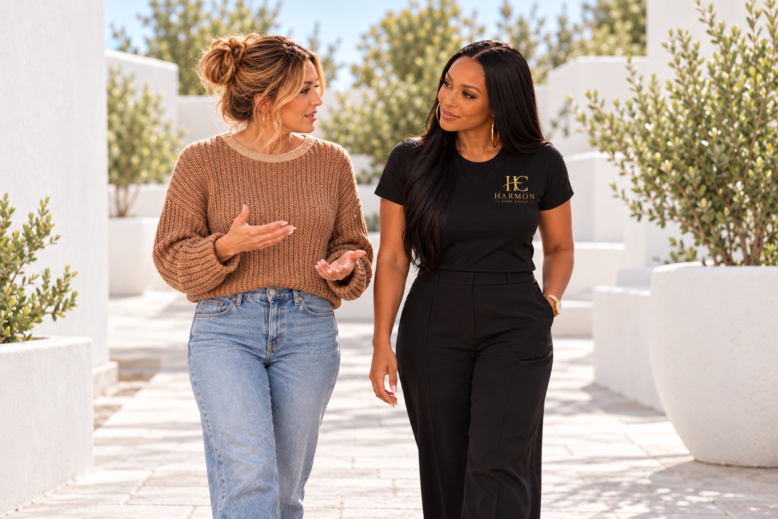 A peer support specialist listening as a woman shares during a walk in a bright courtyard